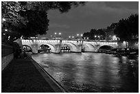 Quay, Seine River, and Pont-Neuf at night. Paris, France (black and white)