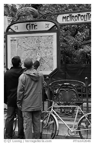 Men looking at a map of the Metro outside Cite station. Paris, France (black and white)
