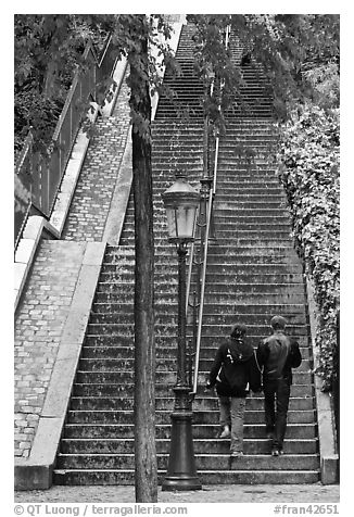 Couple walking up steet stairs, Montmartre. Paris, France