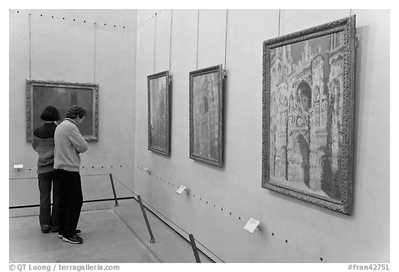 Tourists looking at Monet's Rouen Cathedral, Orsay Museum. Paris, France (black and white)