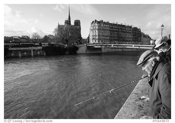 Fishermen on ile Saint Louis, with ile de la Cite in the background. Paris, France (black and white)