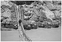 Man crossing a river by rope bridge, Zanskar, Jammu and Kashmir. India (black and white)