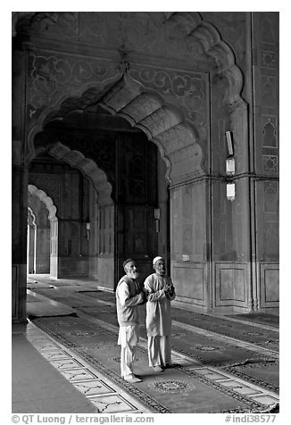 Two muslem men in Jama Masjid mosque prayer hall. New Delhi, India (black and white)