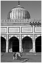 Group of people walking out of prayer hall. New Delhi, India (black and white)