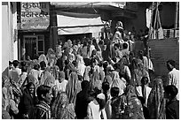 Street with women in colorful sari following wedding procession. Jodhpur, Rajasthan, India (black and white)