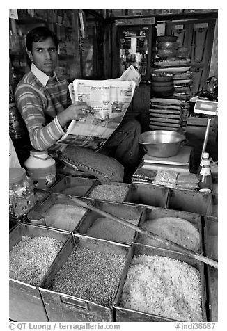 Man with newspaper selling grains, Sardar Market. Jodhpur, Rajasthan, India (black and white)