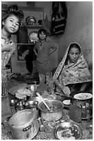 Woman cooking, flanked by two girls. Jodhpur, Rajasthan, India (black and white)