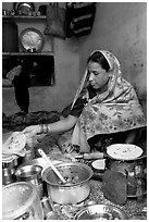 Woman with headscarf stacking chapati bread. Jodhpur, Rajasthan, India (black and white)