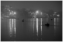 Rowboats and reflected lights on the Ganges River at dusk. Varanasi, Uttar Pradesh, India ( black and white)