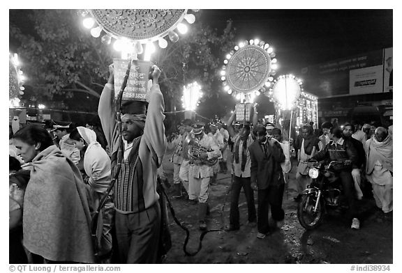 Men carrying bright electric signs during wedding procession. Varanasi, Uttar Pradesh, India (black and white)