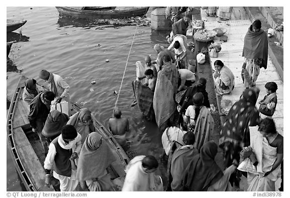 Hindu pilgrims walk out of boat onto Dasaswamedh Ghat. Varanasi, Uttar Pradesh, India (black and white)