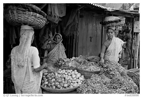 Women with baskets on head buying vegetables, Colaba Market. Mumbai, Maharashtra, India (black and white)