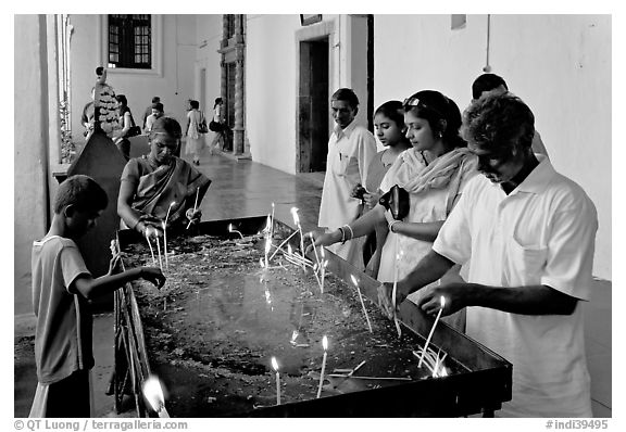 Indian people burning candles, Basilica of Bom Jesus, Old Goa. Goa, India (black and white)