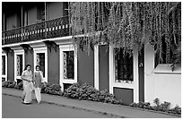 Women strolling past the heritage Panaji Inn, Panjim. Goa, India (black and white)