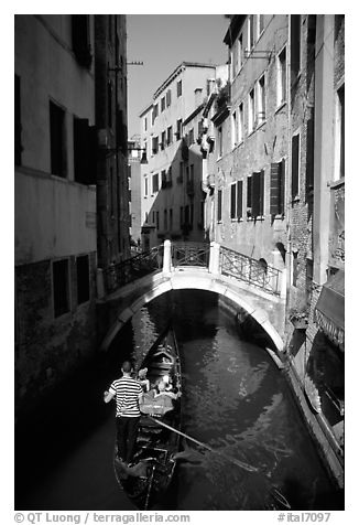 Gondola tour in a picturesque canal with bridge. Venice, Veneto, Italy (black and white)
