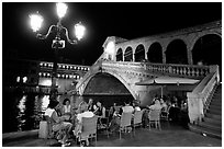 Outdoor cafe terrace,  Rialto Bridge at night. Venice, Veneto, Italy ( black and white)