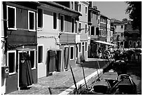 Canal bordered by multicolored  houses, Burano. Venice, Veneto, Italy (black and white)