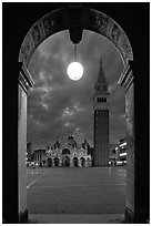 Campanile and Piazza San Marco (Square Saint Mark) seen from arcades at night. Venice, Veneto, Italy (black and white)
