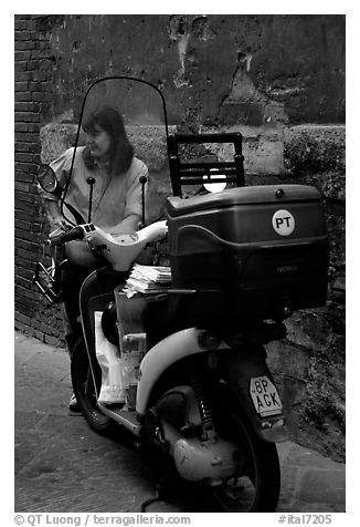 Delivering mail from a scooter. Siena, Tuscany, Italy (black and white)