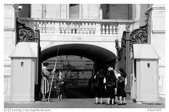 Nuns move past checkpoint manned by Swiss guards. Vatican City