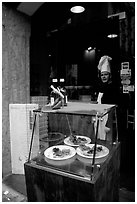 Chef at restaurant doorway with appetizers shown in glass case. Naples, Campania, Italy (black and white)