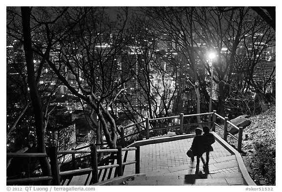 Couple walking down Namsan stairs by night. Seoul, South Korea