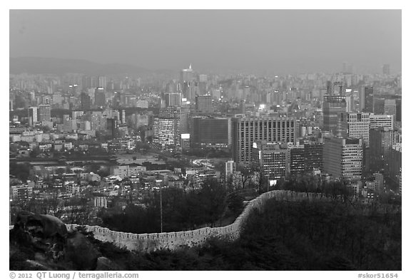 Old fortress wall and high-rises at dusk. Seoul, South Korea (black and white)
