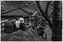 Hikers drinking from foundtain at Sangseonam hermitage, Namsan Mountain. Gyeongju, South Korea (black and white)