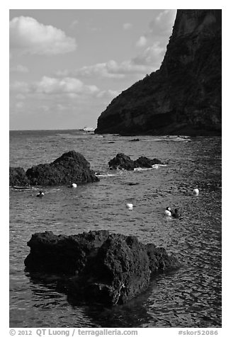 Cove with Haeneyo woman diving. Jeju Island, South Korea (black and white)