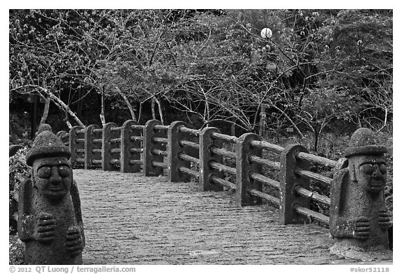 Footbridge and Dolharubang statues, Seogwipo. Jeju Island, South Korea (black and white)