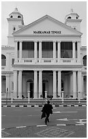 Man in suit crossing streets towards court building. George Town, Penang, Malaysia (black and white)