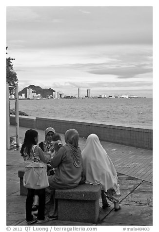 Women on waterfront. George Town, Penang, Malaysia (black and white)