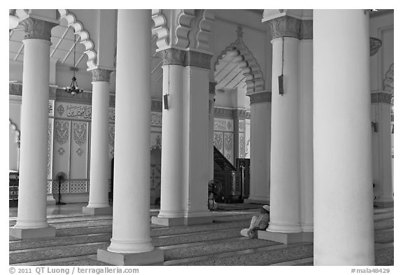 Man in prayer inside Masjid Kapitan Keling mosque. George Town, Penang, Malaysia (black and white)