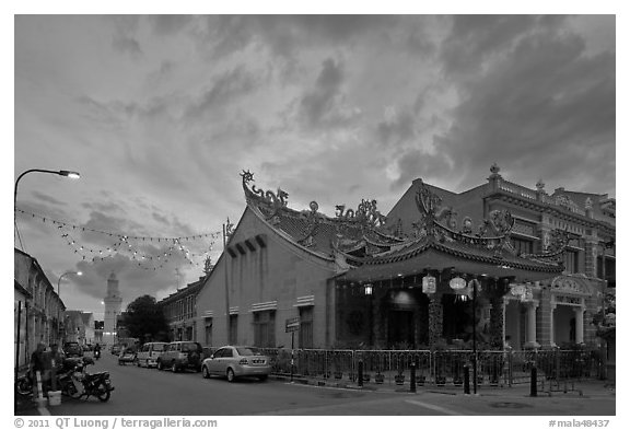 Temple and distant minaret at sunset. George Town, Penang, Malaysia (black and white)