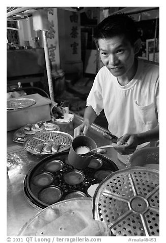 Man preparing mini-pancakes. George Town, Penang, Malaysia (black and white)