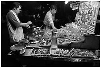 Men arranging skewers on hawker stall. George Town, Penang, Malaysia ( black and white)