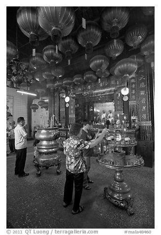 Worshiping inside goddess of Mercy temple. George Town, Penang, Malaysia (black and white)