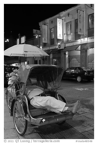 Driver taking nap in trishaw at night. George Town, Penang, Malaysia (black and white)
