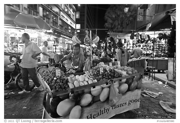 Fruit vendor pushes cart, Jalan Petaling. Kuala Lumpur, Malaysia (black and white)