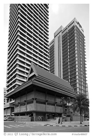 Wooden traditional building at the base of high-rises. Kuala Lumpur, Malaysia (black and white)