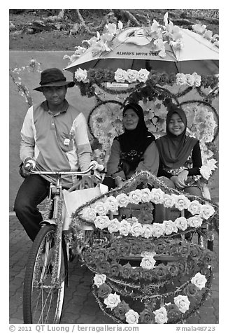 Rider and two women passengers, bicycle rickshaw. Malacca City, Malaysia (black and white)