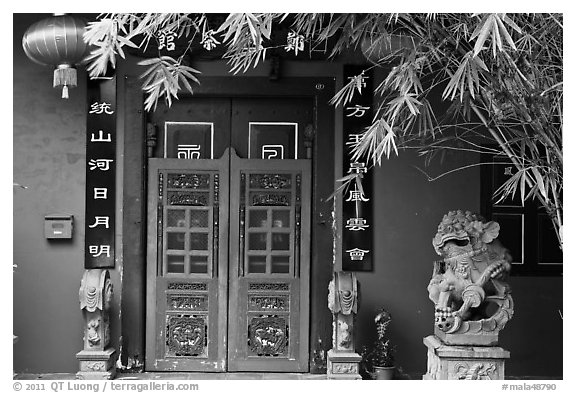 Chinese house entrance with lion sculpture and lanterns. Malacca City, Malaysia (black and white)