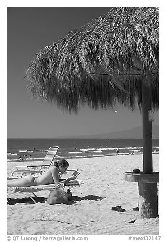 Woman in swimsuit reading on beach chair, Nuevo Vallarta, Nayarit. Jalisco, Mexico (black and white)