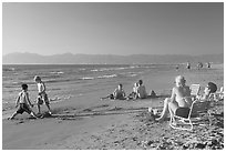 Mothers sitting on beach chairs watching children play in sand, Nuevo Vallarta, Nayarit. Jalisco, Mexico (black and white)