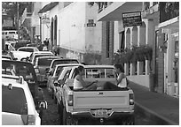 Young women riding in the back of a pick-up truck in a busy street, Puerto Vallarta, Jalisco. Jalisco, Mexico (black and white)