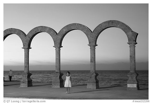 Girl standing by the Malecon arches at sunset, Puerto Vallarta, Jalisco. Jalisco, Mexico