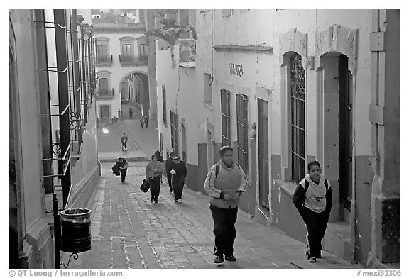 Children heading to school up a narrow cajaon, dawn. Zacatecas, Mexico (black and white)