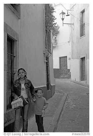 Woman and child walking in a narrow street. Guanajuato, Mexico (black and white)