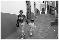 Woman and boy walking down an alleyway. Guanajuato, Mexico (black and white)