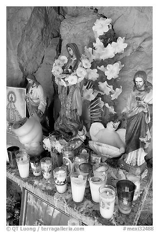 Religious figures and candles in roadside chapel. Mexico